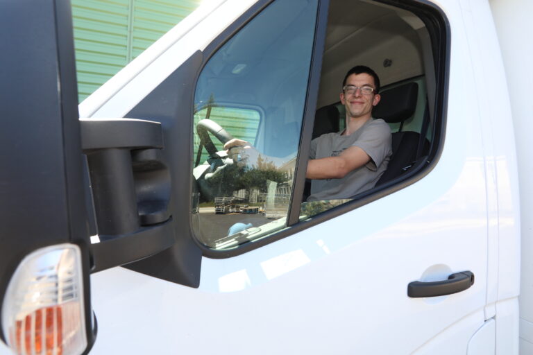 travailleur handicapé au volant d'un camion blanc