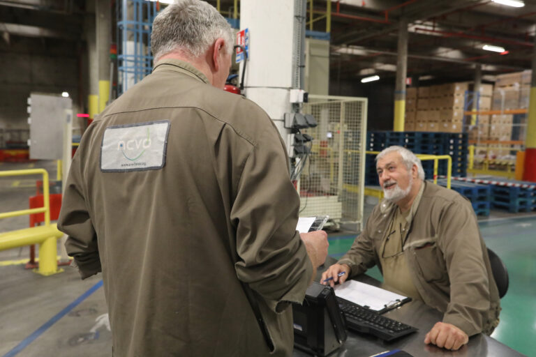 2 personnes en train de discuter dans un hangar